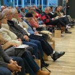Premier rang d'un colloque écoutant un intervenant